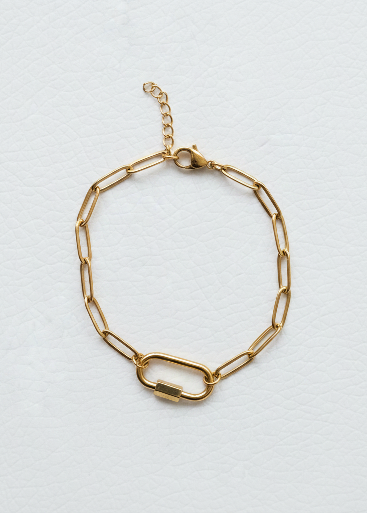 Gold paperclip charm bracelet on white background