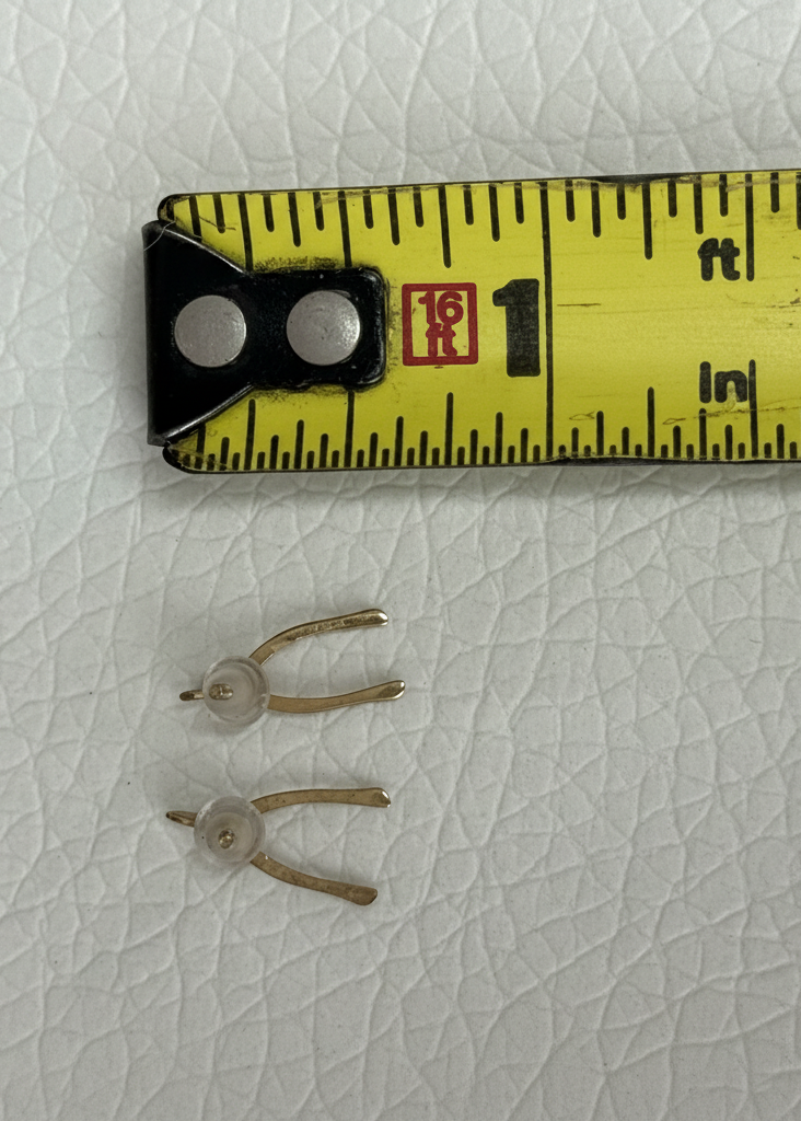 Vintage 9K gold wishbone stud earrings shown next to ruler for scale